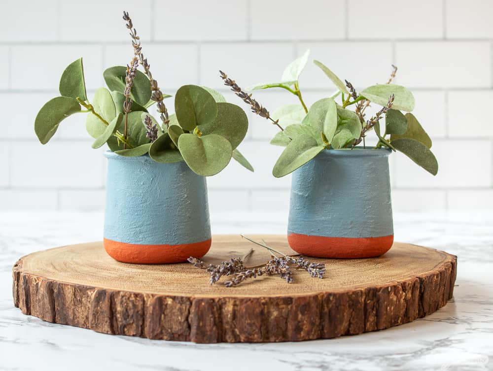 two French yogurt jars with eucalyptus and lavender on a wooden charger
