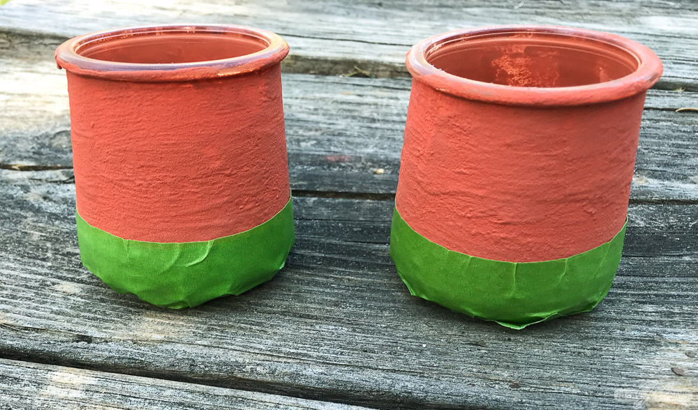 terracotta painted jars with green masking tape on the bottom