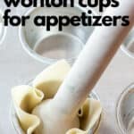 using a wooden tamper to press wonton wrappers into a muffin tin
