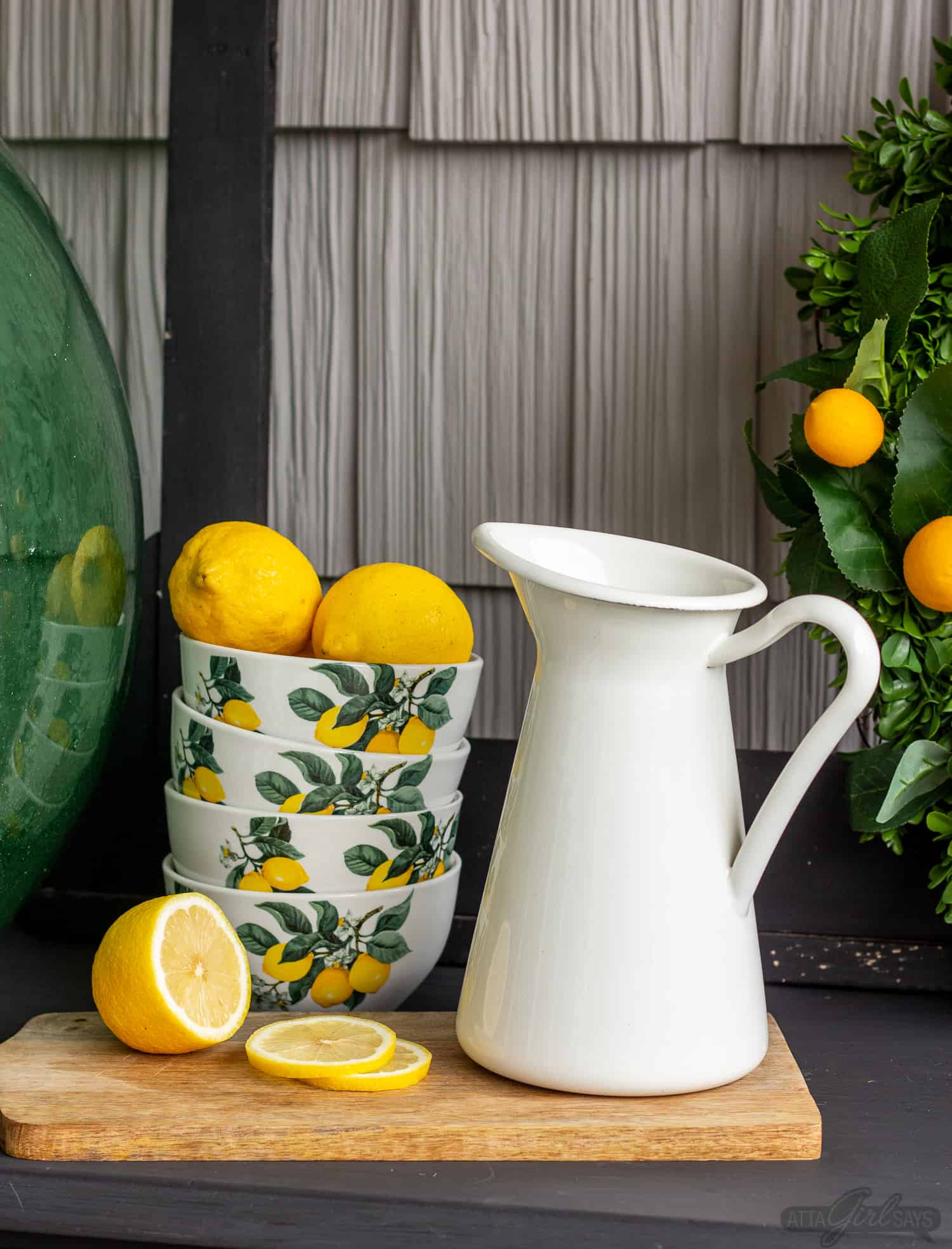 lemon bowls beside a white farmhouse pitcher as part of summer porch decor