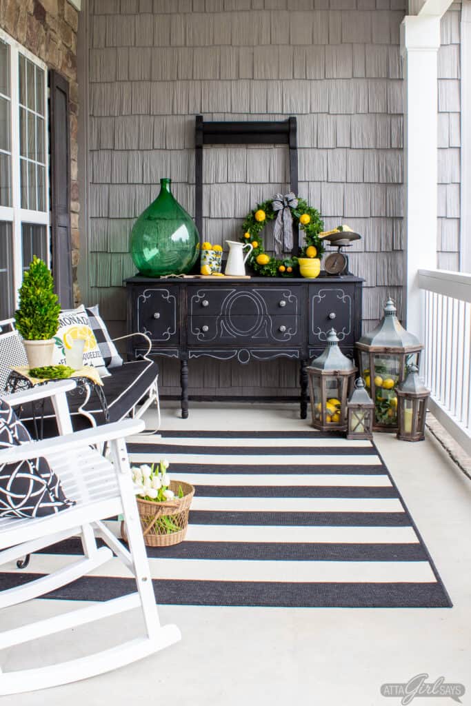 summer front porch decorated with black and white furniture and lemon yellow and green accents