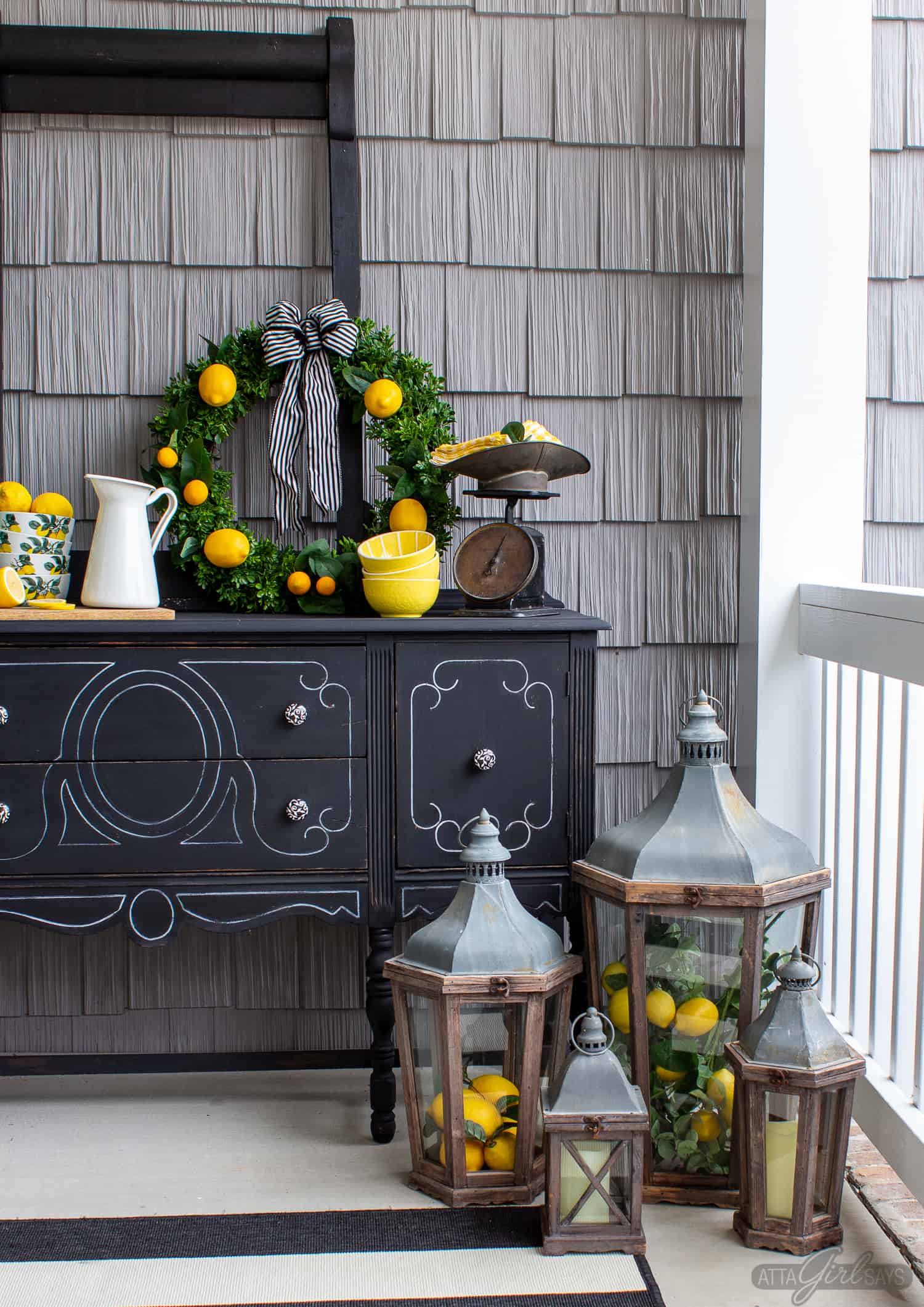 black painted buffet server on a front porch decorated with lemon yellow accents