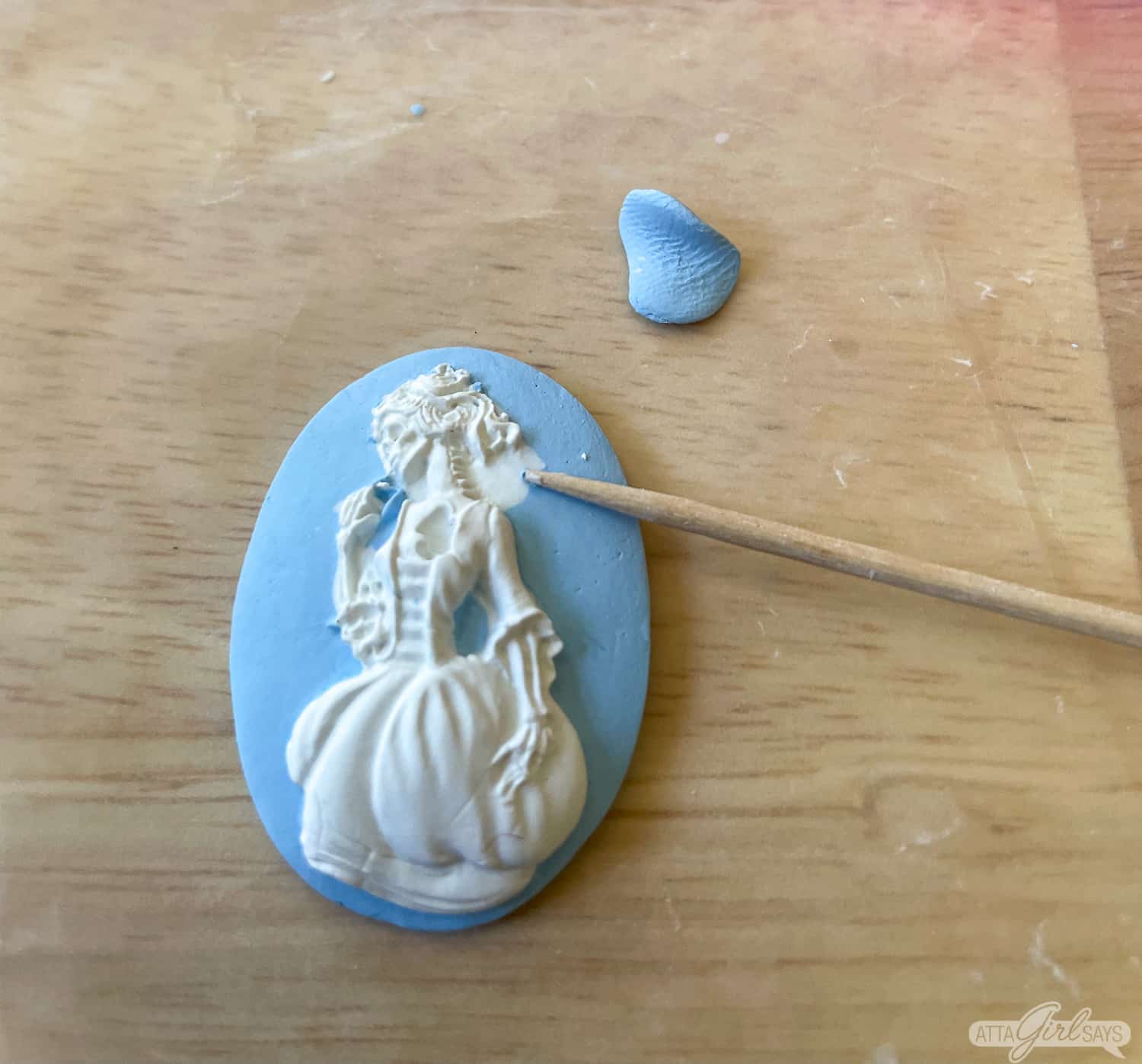 blue and white polymer clay cameo with a Victorian skeleton silhouette