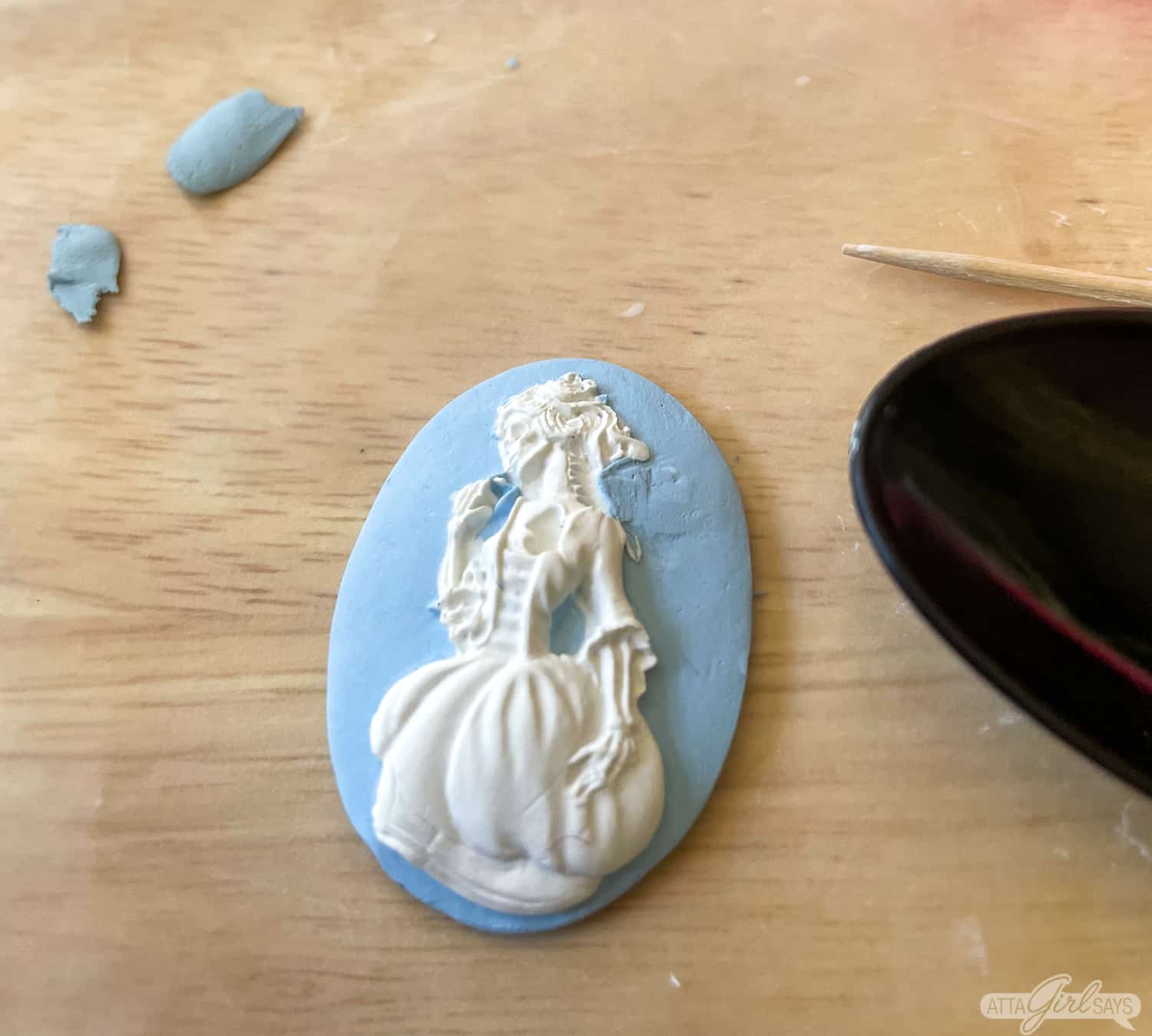 blue and white polymer clay cameo with a Victorian skeleton silhouette in the style of Wedgwood jasperware