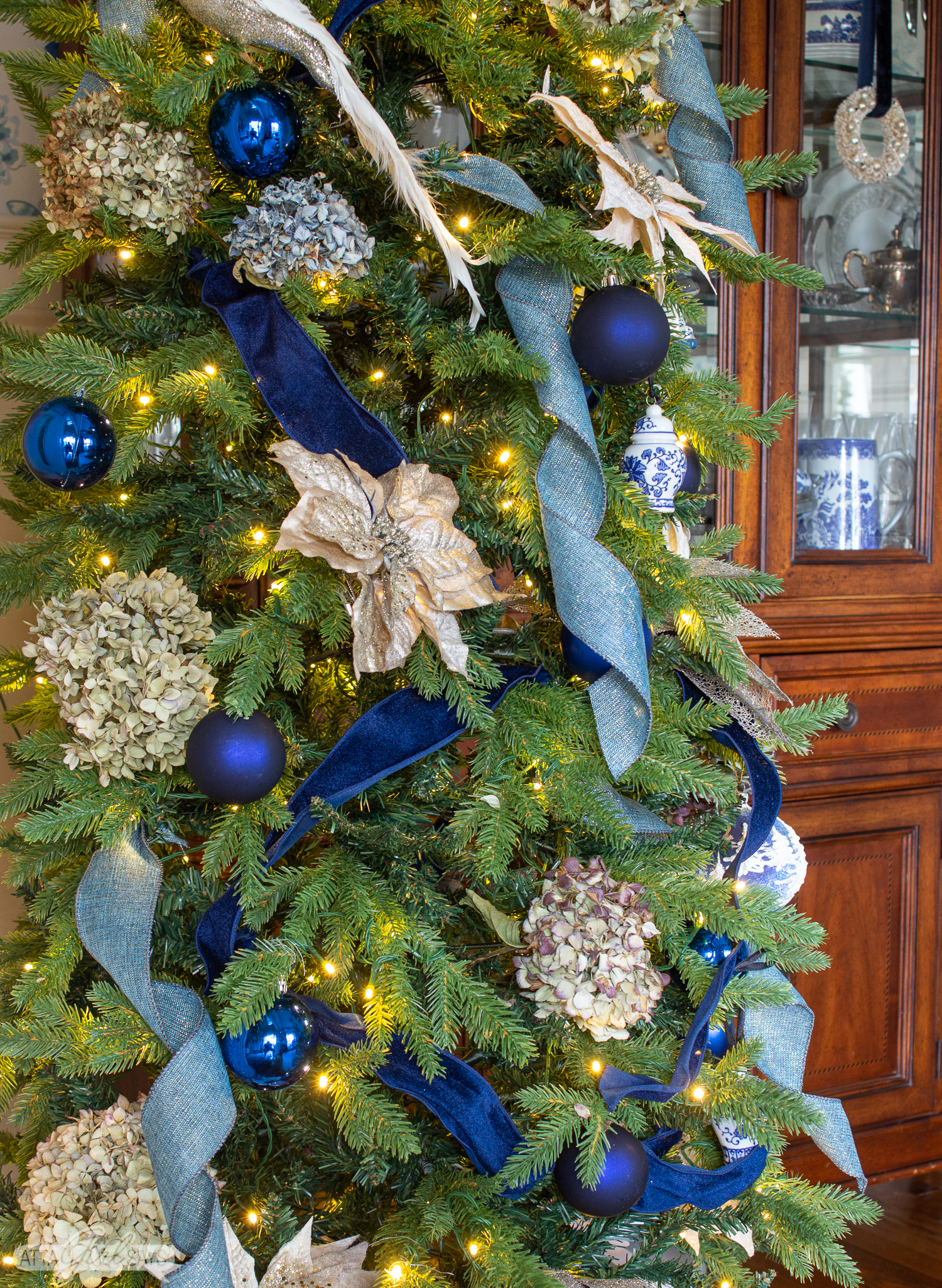 dining room Christmas tree with blue ribbon