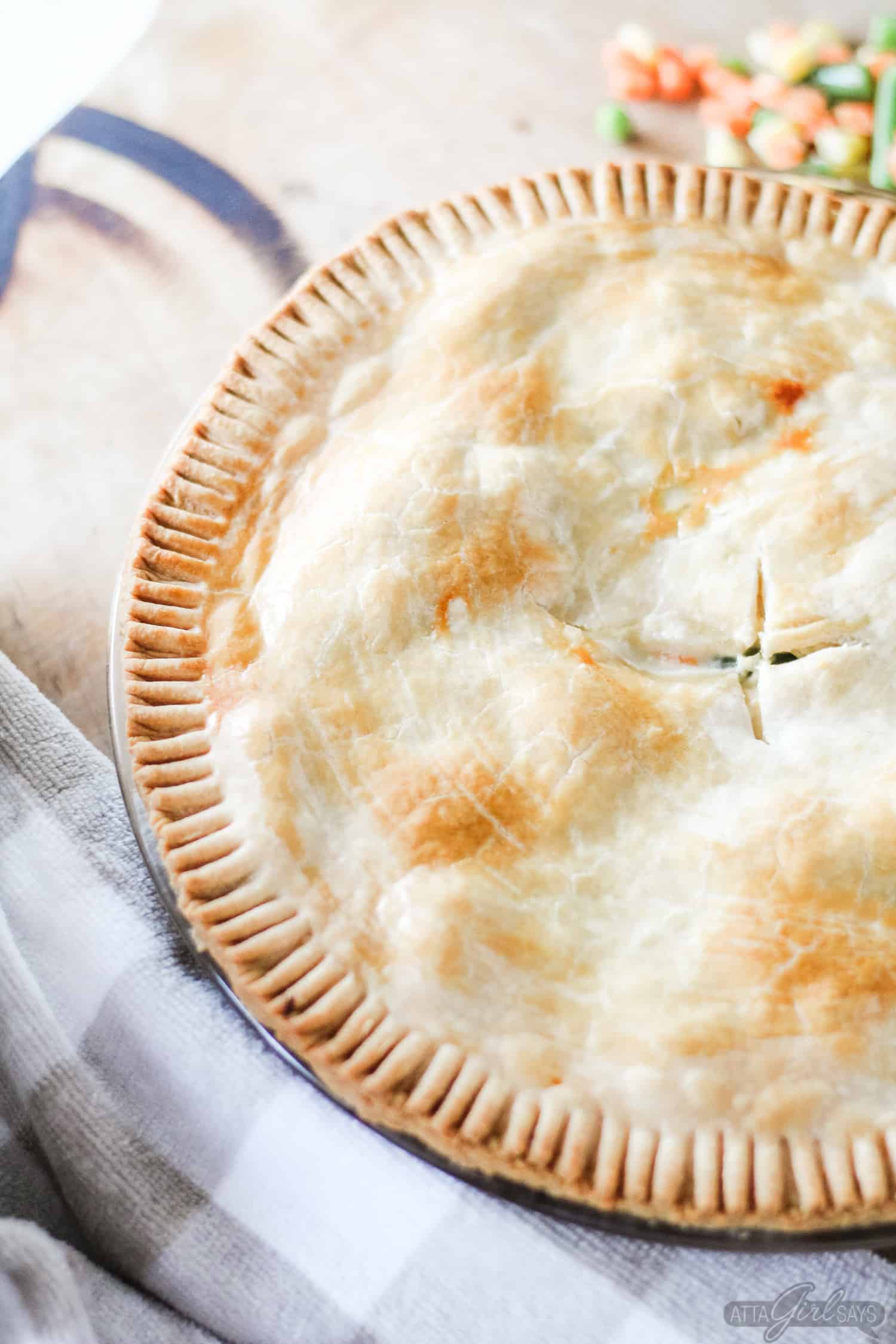 golden brown chicken pot pie on a wooden board