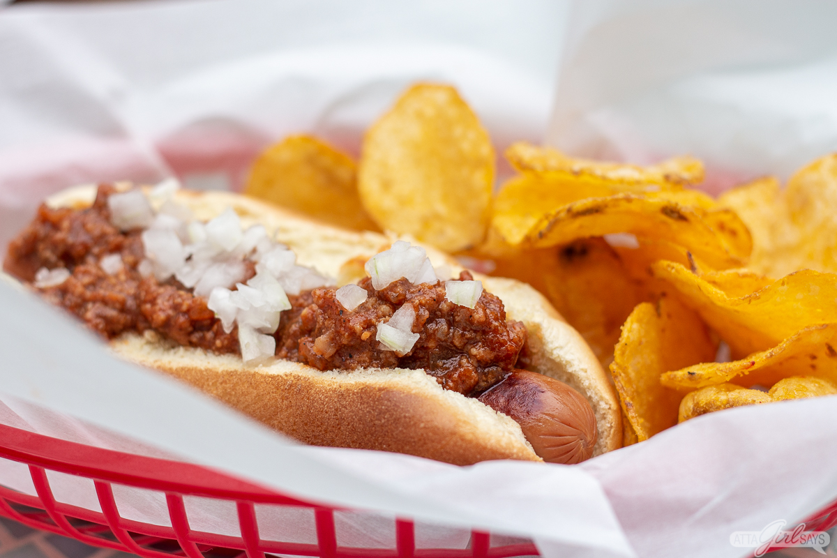 hot dog with chili and a side of chips