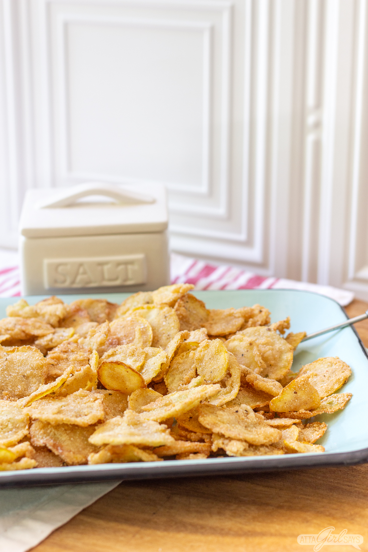 fried squash on a platter with a salt cellar