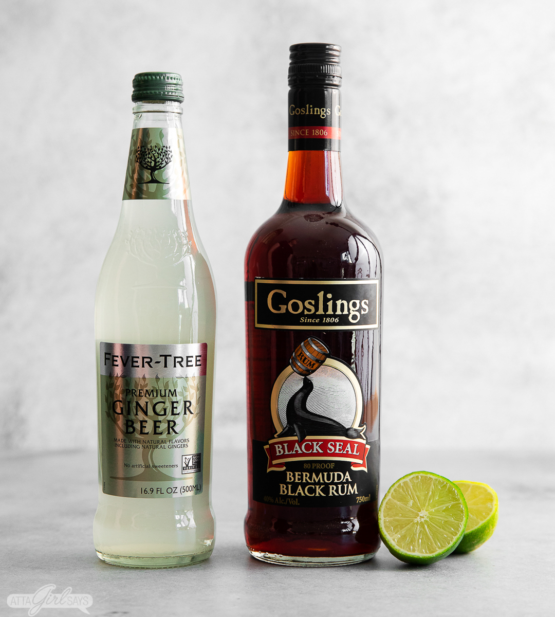ginger beer, dark rum, and a sliced lime on a kitchen counter