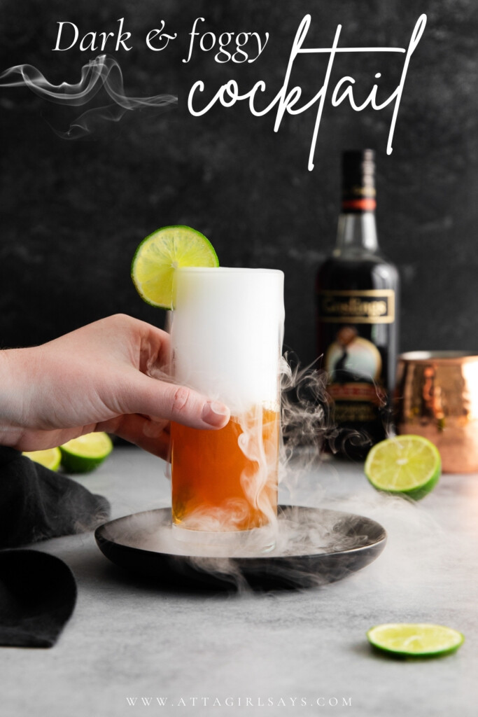 hand holding a smoking dark and story Halloween cocktail