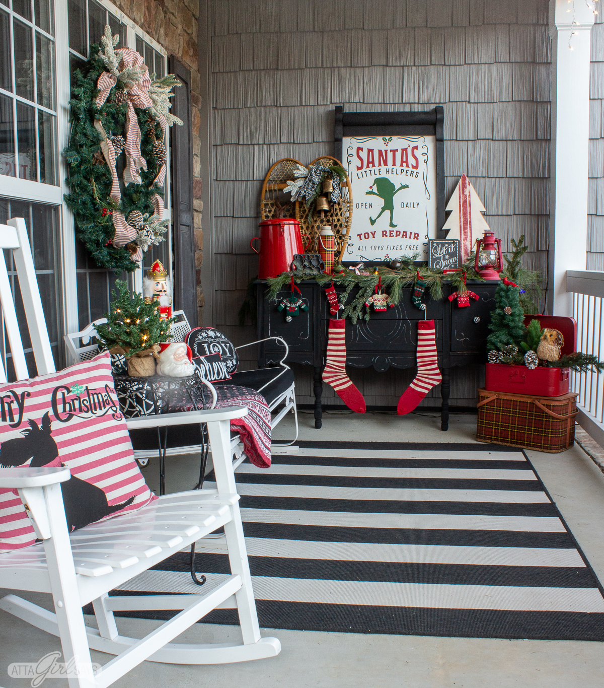 black buffet on a front porch decorated with rustic red and green Christmas decorations