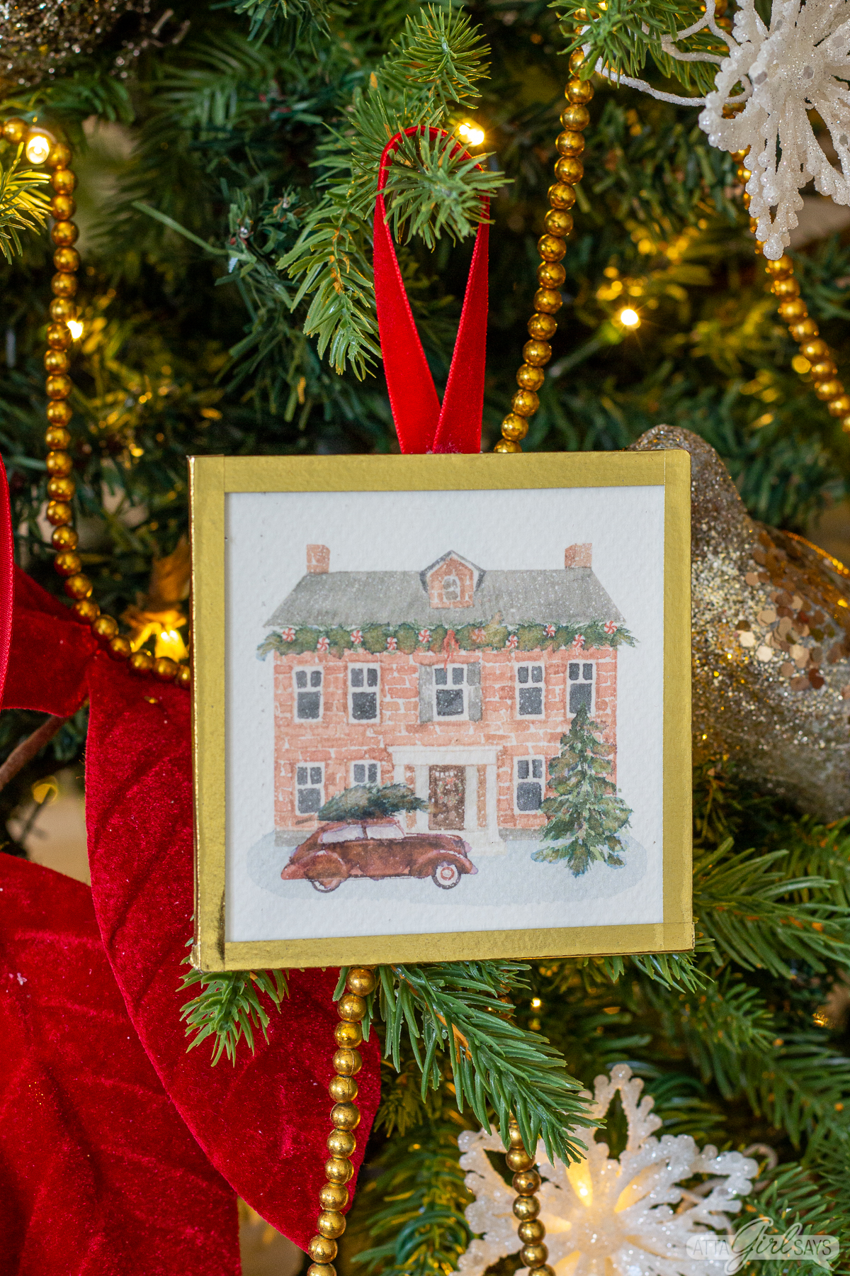 watercolor Christmas ornament of a brick house with a red car in front of it