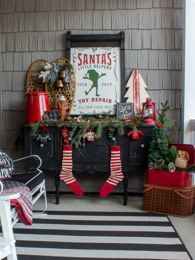black buffet on a front porch decorated with rustic red and green Christmas decorations