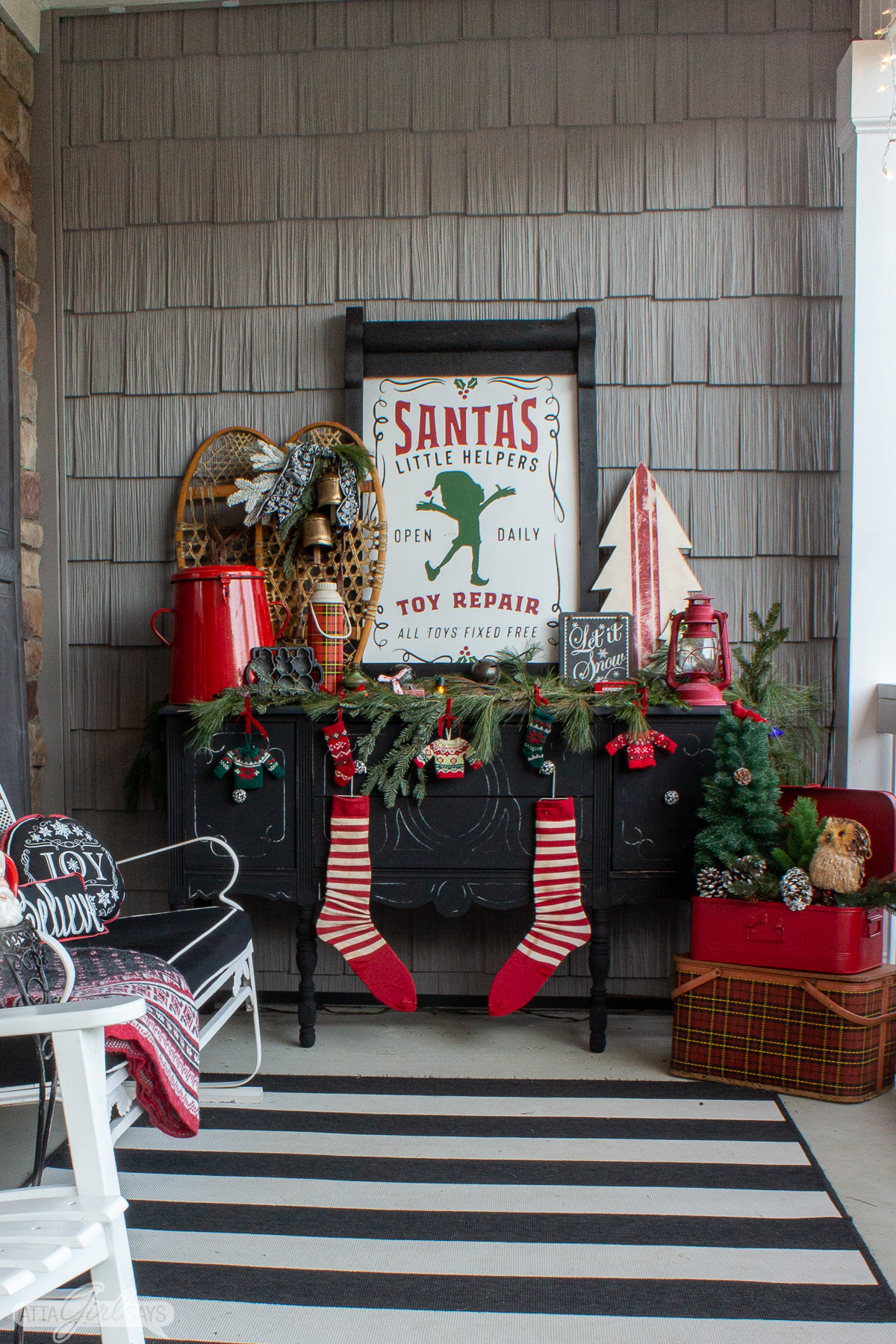 black buffet on a front porch decorated with rustic red and green Christmas decorations