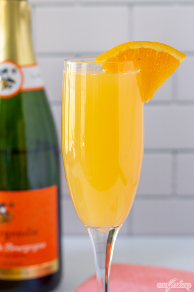 closeup of a mimosa with a champagne bottle