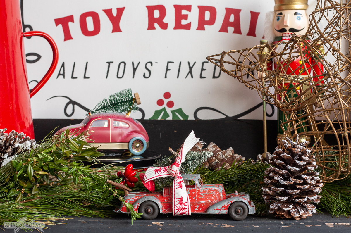 red toy cars with bottle brush Christmas trees in a Christmas display