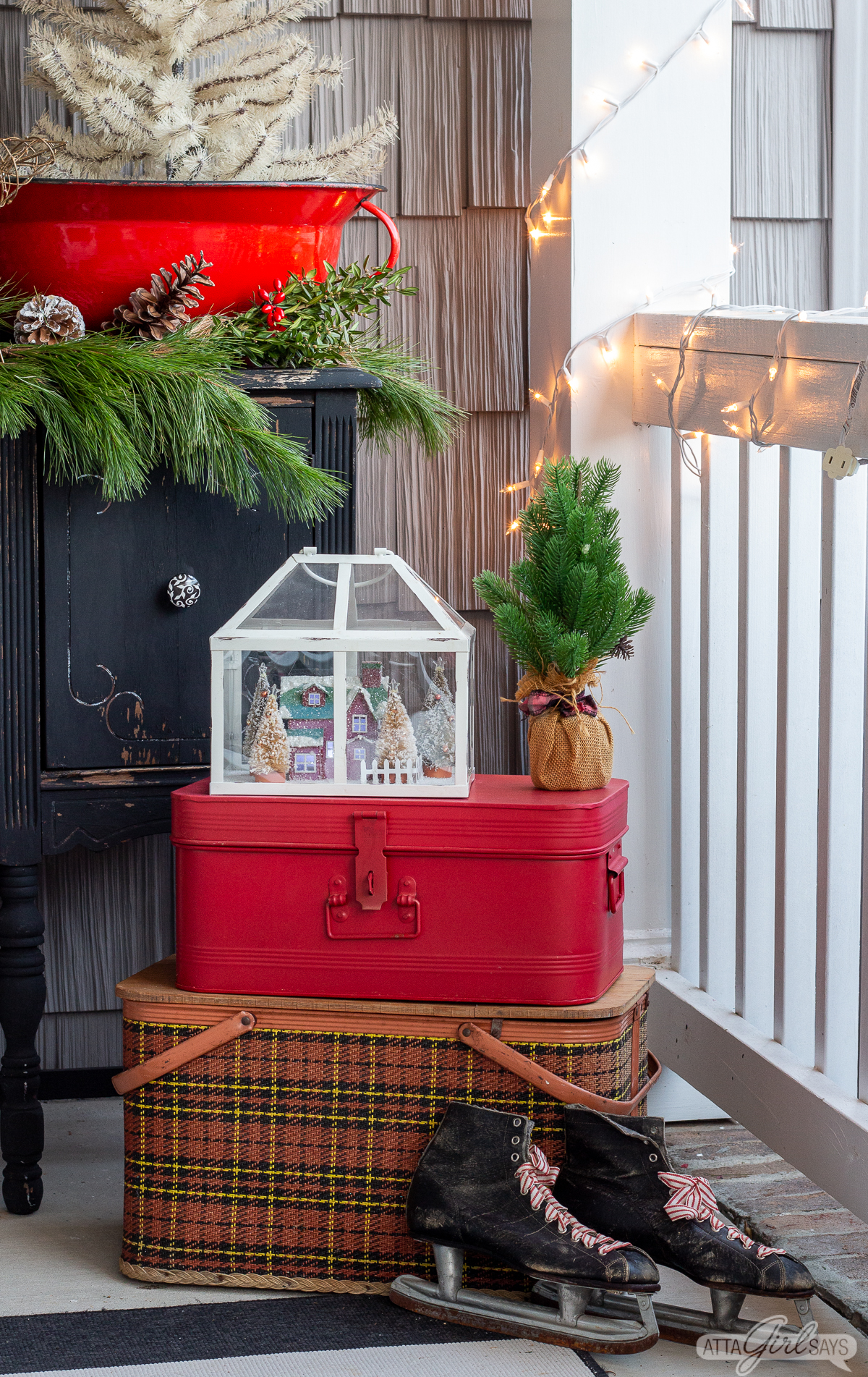 vintage ice skates propped against a red plaid picnic basket on a porch