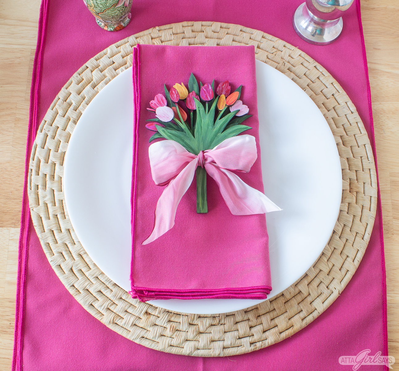 handpainted wooden tulip bouquet tied with ribbon on top of a napkin in a placesetting