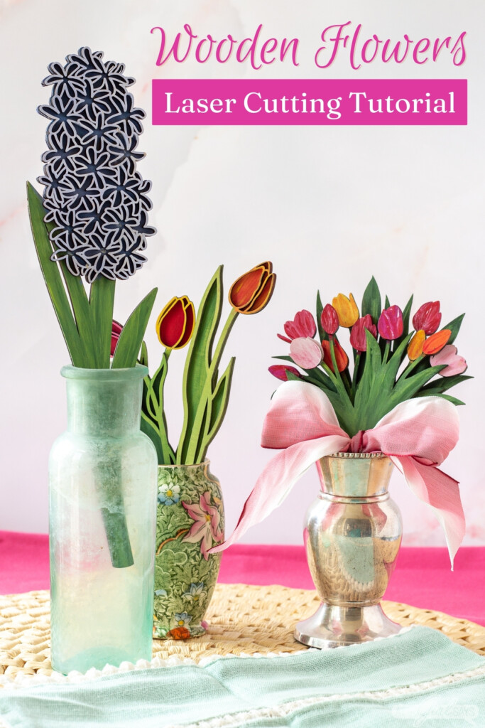 three vases of handpainted laser cut 3D wood flowers on a straw mat