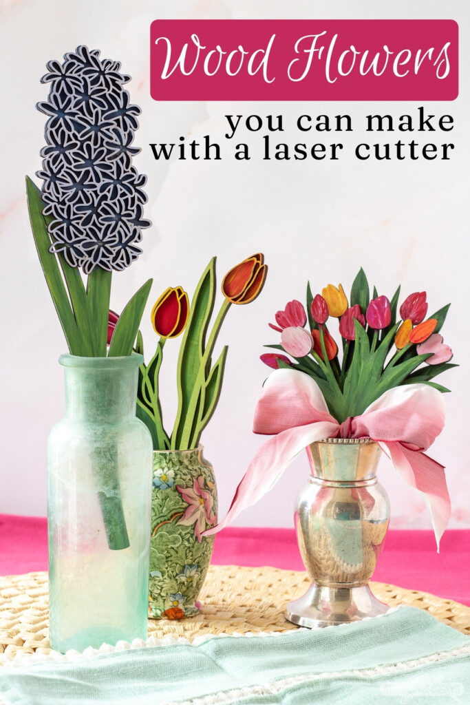 three vases of handpainted laser cut 3D wood flowers on a straw mat