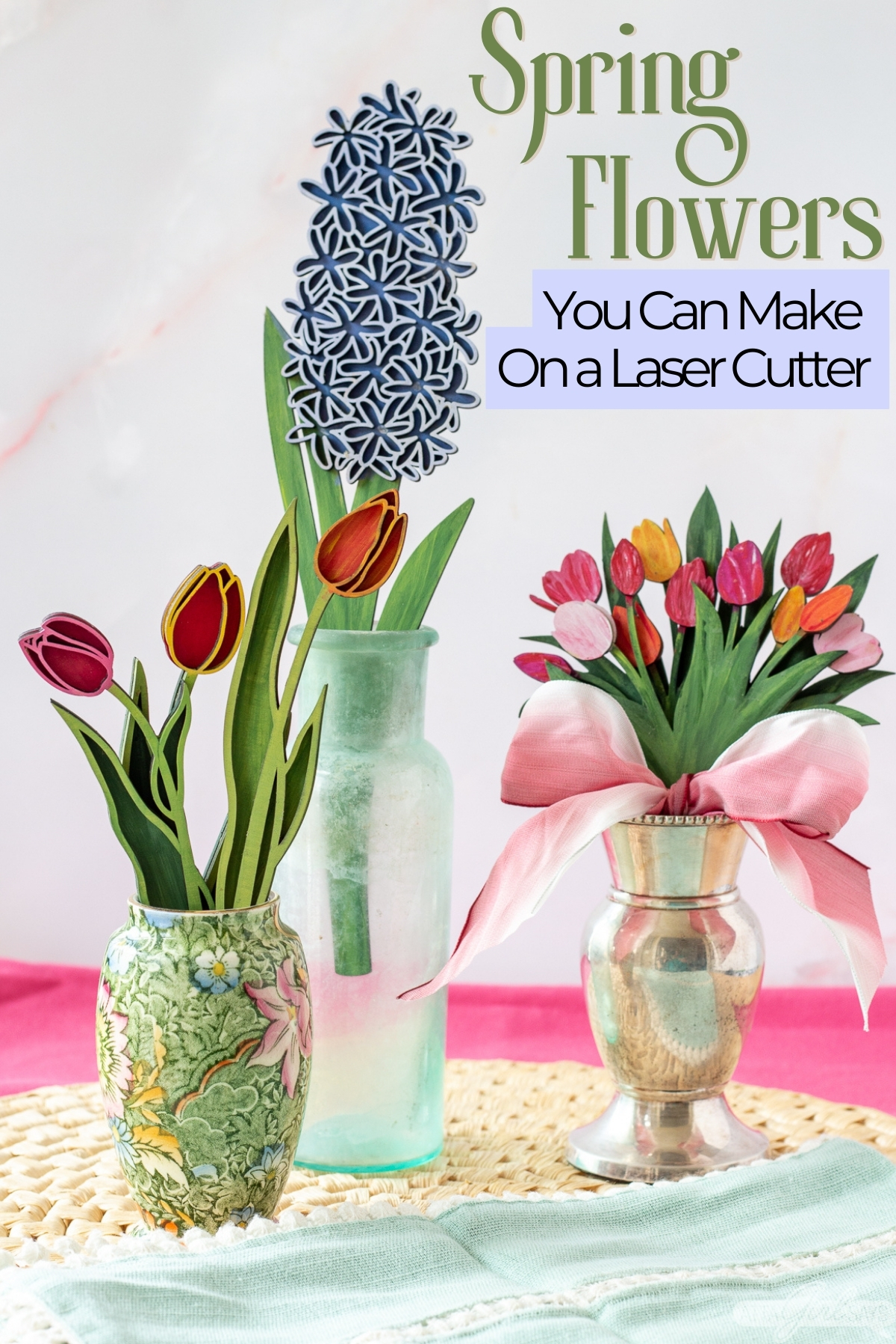 three vases of handpainted laser cut 3D wood flowers on a straw mat