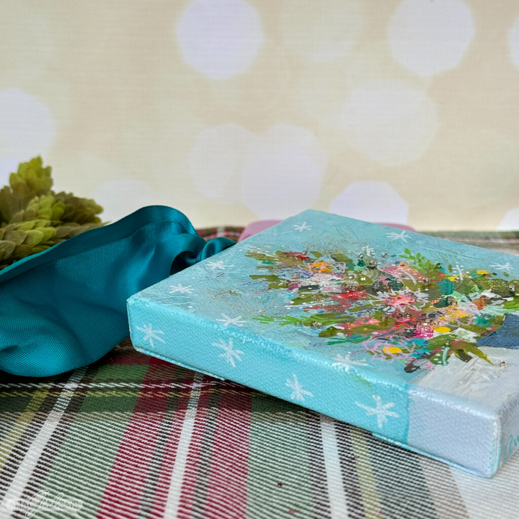 small painting of a Christmas tree with a blue ribbon hanger