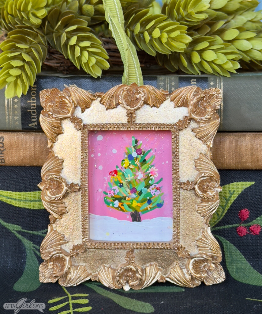 mini Christmas tree painting on a pink background in a gold frame