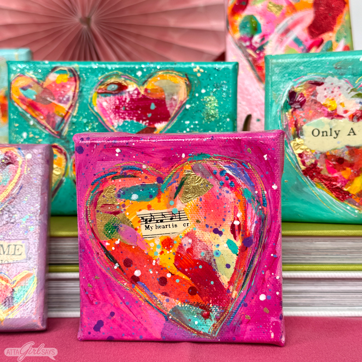 small canvas collage paintings of hearts arranged on books